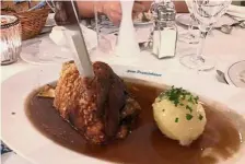  ??  ?? German cuisine of roasted pork knuckle with potato dumpling.