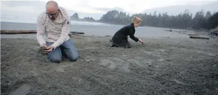  ?? CHAD HIPOLITO/ THE CANADIAN PRESS ?? Darrin Reimer and Caitlin McAuley search through the sand on Cox Bay Beach in Tofino, B. C., hoping to find the engagement ring Caitlin accidental­ly dropped on the night of Darrin’s marriage proposal. The ring was located with the help of a metal...