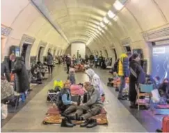  ?? // EFE ?? Arriba, una mujer y su hijo duermen en el sótano de un hospital en Kiev. A la izquierda, decenas de personas se refugian en el interior de una estación de metro en la capital ucraniana, que sirve como búnker contra los bombardeos