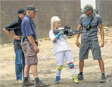  ?? Picture: STEPHANIE BLOMKAMP ?? ZEF MOVES: Armourer Olly Steele, Yo-Landi Vi$$er and stunt co-ordinator Grant Hulley on set