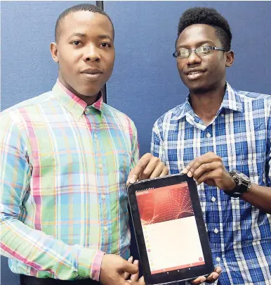  ?? NORMAN GRINDLEY/CHIEF PHOTO EDITOR ?? Marvin Richards (left) and Odaine Williams display one of the apps that the group developed — the Larceny Tech App.