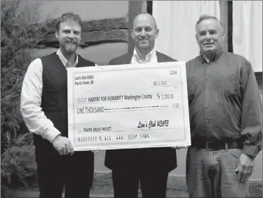  ?? LYNN KUTTER ENTERPRISE-LEADER ?? Mark Engle, president of Prairie Grove Lions Club, center, presents a $1,000 donation to Habitat for Humanity of Washington County, represente­d by Jason Kindall, excecutive director, (left) and volunteer Patrick Moore of Prairie Grove. Habitat for...