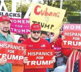  ??  ?? MIAMI: Supporters for Republican presidenti­al nominee Donald Trump hold signs at a rally. — AFP