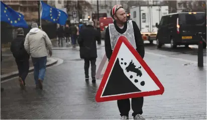  ??  ?? AN ANTI-BREXIT PROTESTER demonstrat­es outside the Houses of Parliament in London yesterday.