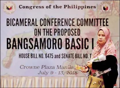  ?? MICHAEL VARCAS ?? A woman walks past a sign in a hotel in Ortigas as senators and congressme­n assemble before the bicameral conference committee meeting on the Bangsamoro Basic Law yesterday.