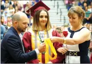  ??  ?? Avarie Coones’ parents pick up her high-honor medallion just before going on stage to present it during Gentry High School graduation ceremonies on Sunday.