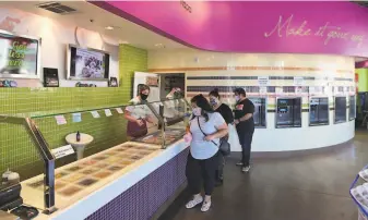  ??  ?? Customers buy frozen yogurt at Yobelle Frozen Yogurt II in Napa. Like many other businesses, the shop is taking advantage of the county’s liberalize­d shelterinp­lace rules.