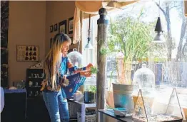  ?? DYLAN COLE NYT ?? Vicki Liston checks on her hydroponic tower at her home in Clovis, N.M. Interest in the soil-free growing method has surged during the pandemic.