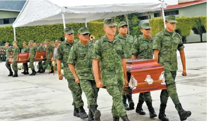  ?? HÉCTOR TÉLLEZ ?? Militares cargan los féretros de sus compañeros caídos en una emboscada.