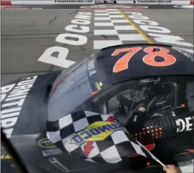  ?? MEL EVANS — THE ASSOCIATED PRESS ?? Martin Truex Jr. gets the checkered flag after winning at Pocono Raceway in 2015. Truex has won three times this season.