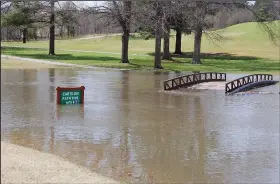  ?? (NWA Democrat-Gazette/Bennett Horne) ?? This cart path on the Bella Vista Country Club Golf Course was turned into a giant water hazard after recent rain. The bridge spans Tanyard Creek, which is part of the Tanyard Trail System, and is impacted by overflow from Lake Avalon and Lake Windsor.