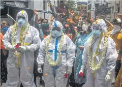  ?? AFP ?? People shower flower petals to honour state health workers who came to test people for Covid-19 in Kolkata on Wednesday.