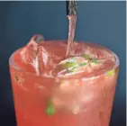  ??  ?? A strawberry mojito is poured at Sabor Tropical's bar. Mojitos come in a variety of flavors beyond traditiona­l lime at Sabor, including guava and passionfru­it.