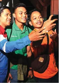  ?? ALLEX QOMARULLA/JAWA POS ?? BINTANG MUDA: Rachmat Irianto melayani permintaan wefie setiba di Stasiun Pasar Turi, Surabaya, tadi malam (13/3).