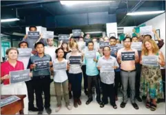  ?? SIV CHANNA/THE CAMBODIA DAILY ?? staffers stand with placards bearing the slogan ‘Save the Daily’ at their Phnom Penh office.