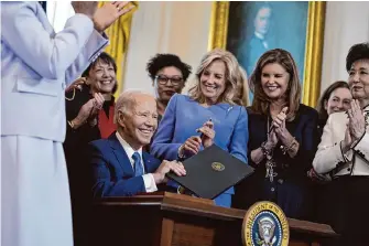  ?? Evan Vucci/Associated Press ?? President Joe Biden signs an executive order on women’s health Monday during a Women’s History Month event in the East Room of the White House.