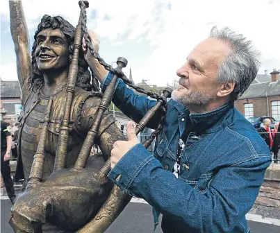  ?? Picture: Andrew Cawley. ?? Former AC/DC bassist Mark Evans at the statue of Bon Scott in Kirriemuir.