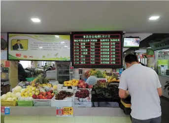  ??  ?? Daily food detection results are displayed on a screen at the Gudang Wet Market.