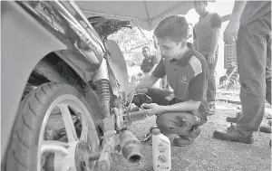  ?? — Gambar Bernama ?? Seorang pelajar IKTBN Dusun Tua, Yusri Hafiz (kanan) melakukan kerja menukar minyak enjin pada sebuah motosikal sewaktu aktiviti tukar minyak hitam motosikal percuma di Balai Raya Kampung Sesapan Batu Rembau, Beranang pada lawatan Menteri Belia dan Sukan Syed Saddiq Syed Abdul Rahman di daerah Hulu Langat, dekat Semenyih, semalam.