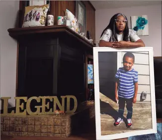  ?? Charlie Riedel / Associated Press ?? Charron Powell stands with a photo of her son, LeGend Talieferro, at her home in Raytown, Mo., on Oct. 3. LeGend was 4 years old when he was fatally shot June 29, 2020, as he was sleeping in an apartment while staying with his father.