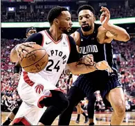  ?? AP/Canadian Press/FRANK GUNN ?? Toronto forward Norman Powell (24) drives to the basket against Orlando center Khem Birch during the Raptors’ 115-96 victory over the Magic on Tuesday in Toronto. Powell finished with 11 points as the Raptors clinched the series.