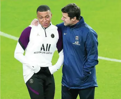  ?? REUTERS ?? Pochettino habla con Mbappé sobre el césped del Camp Nou en el entrenamie­nto de ayer