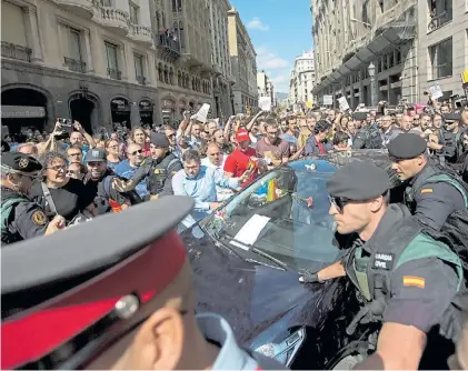  ?? AP ?? Apoyo. Independen­tistas catalanes saludan a uno de los funcionari­os arrestados por la Guardia Civil.