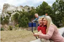  ??  ?? A mother and her two children takes a “selfie” at Mount Rushmore National Memorial on April 23, 2020, in Keystone, South Dakota.—AFP photos