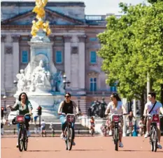  ?? Foto: Lipinski/PA Wire/dpa ?? Radfahrer genießen vor dem Buckingham Palace in London das sommerlich­e Wetter. Sechs Menschen dürfen sich im Freien wieder treffen.