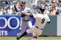  ?? JEFF CHIU/AP ?? Marlins shortstop JT Riddle throws to first base after forcing out the Giants’ Brandon Belt to complete a double play in the fourth inning.