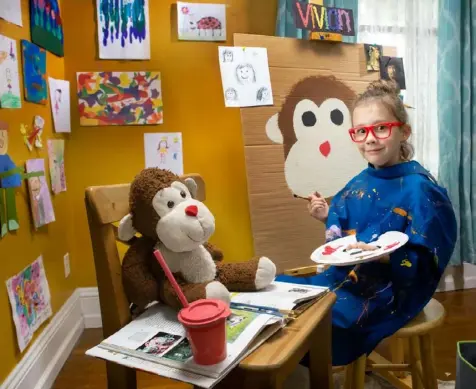  ??  ?? Vivian Cramer paints a portrait of her pal Jack using a canvas made from cardboard and a palette made from a paper plate.