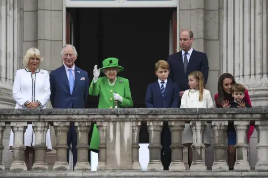  ?? Roland Hoskins, WPA Pool, Getty Images ?? Queen Elizabeth II waves while other members of the British royal family stand on the balcony during the Platinum Pageant on Sunday in London.