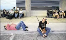  ?? ALLEN EYESTONE / THE PALM BEACH POST ?? Mike Taylor and Beth Alward, of Portland, Maine, wait for a ride to their cruise ship at Fort Lauderdale-Hollywood Internatio­nal Airport on Jan. 6 after the terminal shooting incident.