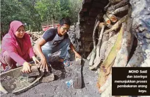  ??  ?? MOHD Saidi dan isterinya menunjukka­n proses pembakaran arang
kayu.