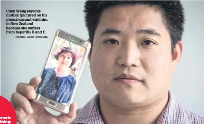  ?? Picture / Jason Oxenham ?? Chen Wang says his mother (pictured on his phone) cannot visit him in New Zealand because she suffers from hepatitis B and C.