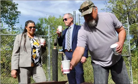  ?? GEOFFREY PLANT/Taos News ?? Frank Rendon, water operator for the Dixon Mutual Domestic Water Consumers Associatio­n, fills a cup with some of the community’s drinking water. Sampling the water behind Rendon are Earthea Nance, Region 6 administra­tor for the U.S. Environmen­tal Protection Agency, and state Environmen­t Secretary James Kenney. Rendon noted that ‘we don’t need to chlorinate it. That’s how pure it is.’