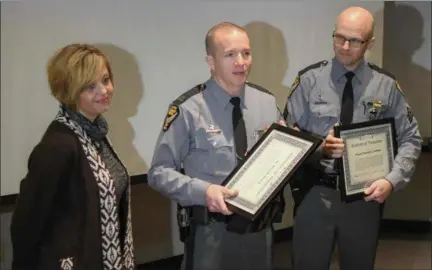  ?? ERIC BONZAR — THE MORNING JOURNAL ?? Ohio State Highway Patrol Capt. Chris Zurcher, center, presents Sgt. Timmothy Hoffman and Michelle Dostall each with a certificat­e of recognitio­n Dec. 27, for their efforts which saved the life of Grafton resident Jerry Fowle.