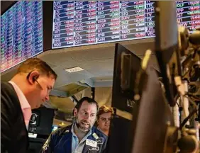  ?? Seth Wenig / Associated Press ?? Traders on Thursday work on the floor at the New York Stock Exchange in New York. Stocks fell in trading on Wall Street.