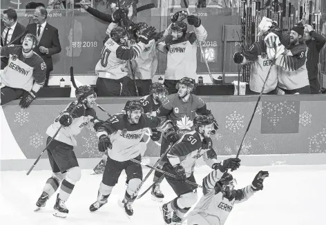  ??  ?? Canada defenceman Mat Robinson looks on as Germany players celebrate after defeating Canada to advance to the gold medal game in Olympic men’s hockey semifinal action at the 2018 Olympic Winter Games in Gangneung, South Korea, Friday, Feb. 23, 2018.