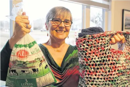  ?? DANIEL BROWN/THE GUARDIAN ?? Anna Farquhar showcases a standard milk bag and one of the tote bags that she recycles and sells for charity. Since being featured in a December 2019 edition of The Guardian, she has received more than 300 milk bag donations from Islanders.