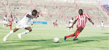  ?? ?? Chicken Inn’s Malvin Gaki (left) forces his way past Dominic Jaricha (right) of Bulawayo City during a Castle Lager Premier Soccer League match played at Barbourfie­lds Stadium yesterday