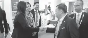  ??  ?? LAWAT: Dr Sim berjabat tangan dengan salah seorang peserta pameran sempena ASCOMOS 2017 di Kuching, semalam.