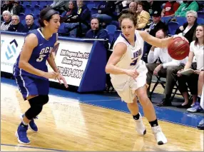  ?? Photo courtesy of JBU Sports Informatio­n ?? John Brown junior Jana Schammel drives by Oklahoma City’s Daniela Galindo during Thursday’s game at Bill George Arena. The Stars defeated the Golden Eagles 75-62.