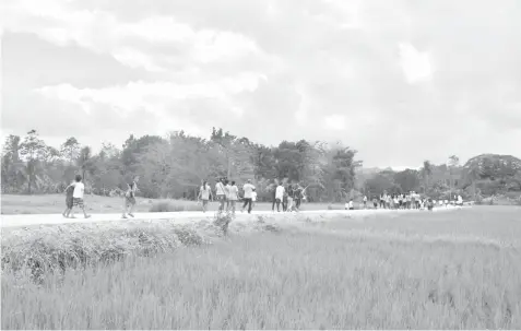  ??  ?? Residents of Brgy. Anopog along with the teachers and students pass through the new access road.