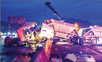  ?? Austin Dave/The Signal ?? California Highway Patrol and Freeway Service Patrol units work to clear debris following a big rig crash on Highway 14 Wednesday morning. The crash caused traffic — seen in the background — to back up.