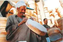  ?? Courtesy: Saeed Shehata ?? Craftsmen put finishing touches on their sieves in a Cairo workshop. Sieve-making is a dying trade in today’s Egypt.