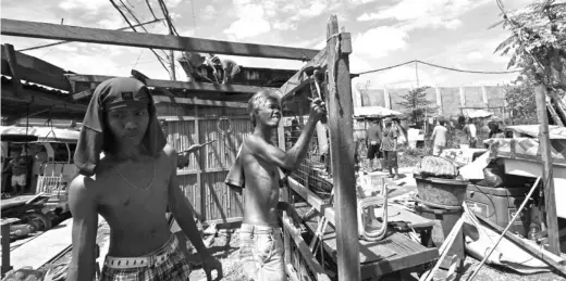  ?? ALDO NELBERT BANAYNAL ?? Members of the demolition team tear down several houses along F. Villa Street in Barangay T. Padilla.