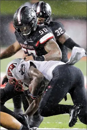  ?? Arkansas Democrat-Gazette/THOMAS METTHE ?? Arkansas State defensive lineman William Bradley-King (50) takes down UNLV running back Lexington Thomas during Saturday’s game in Jonesboro. Bradley-King had nine tackles and 11/2 sacks during the victory and was named the Sun Belt Conference Defensive Player of the Week.