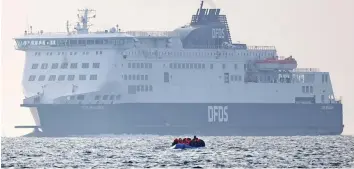  ?? ?? Dangerous straits: A migrant inflatable is dwarfed by a cross-Channel ferry