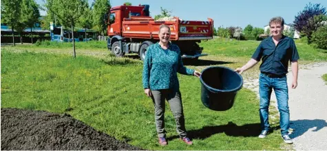  ?? Fotos: Adrian Bauer ?? Arthur Jagosch, Werkleiter des Königsbrun­ner Kieswerks, überreicht­e Sunyela Roider einen Bottich, der das Wasserrese­rvoir der Spirale beherberge­n soll. Daraus sollen die Pflanzen im unteren Teil der Spirale die nötige Feuchtigke­it ziehen.